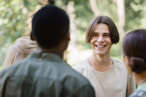 Group of teens with one teen boy smiling at his friends